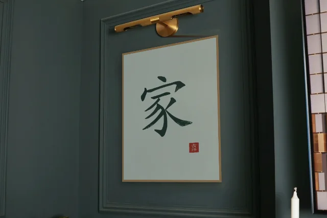 Famille à l'encre, jade : affiche encadrée chêne sous une lampe de tableau, mur vert profond