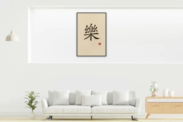 Joie à l'encre, sable ocre : affiche encadrée noir dans la niche éclairée d'un salon blanc