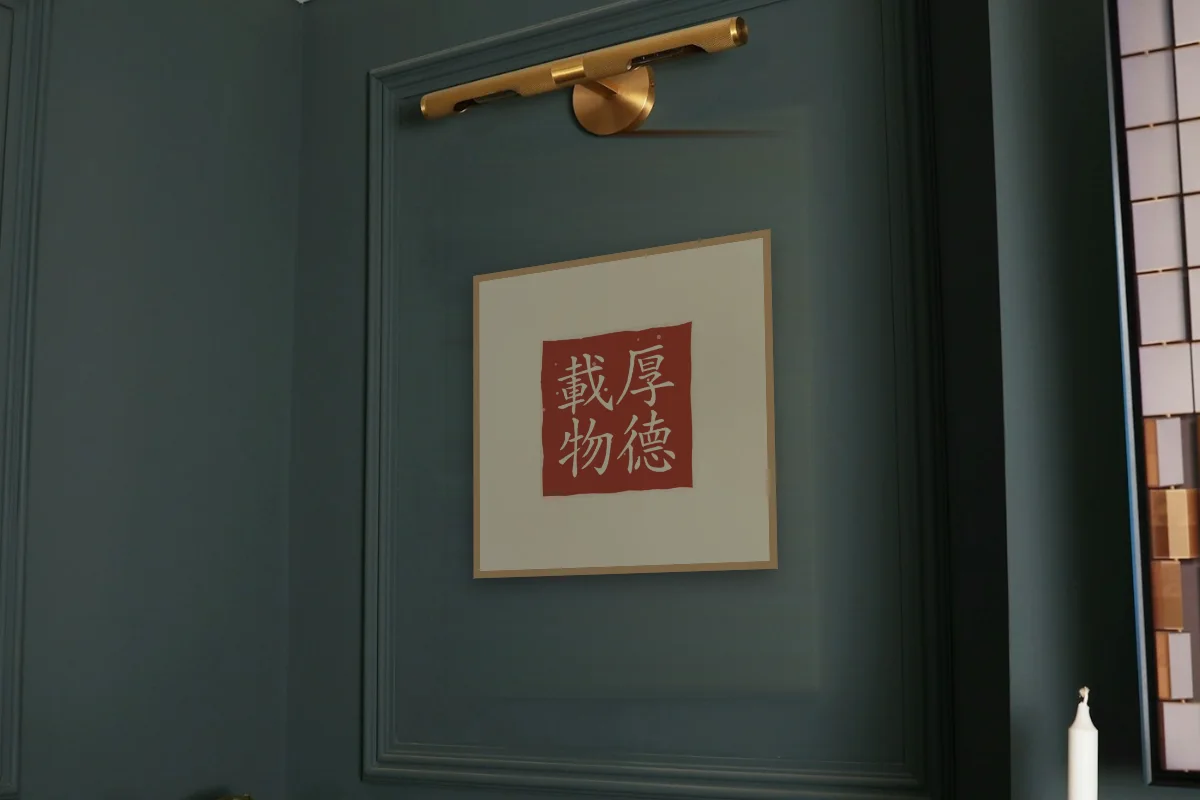Une vertu profonde en sceau, sable ocre. Photo d'illustration : Affiche encadrée chêne sous une lampe de tableau, mur vert profond, œuvre en 50 × 50 cm, à l'échelle. Photo de la pièce : Paul Yarnell (Unsplash).