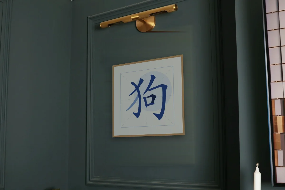 Signe du Chien en aplats, porcelaine bleue. Photo d'illustration : Affiche encadrée chêne sous une lampe de tableau, mur vert profond, œuvre en 50 × 50 cm, à l'échelle. Photo de la pièce : Paul Yarnell (Unsplash).