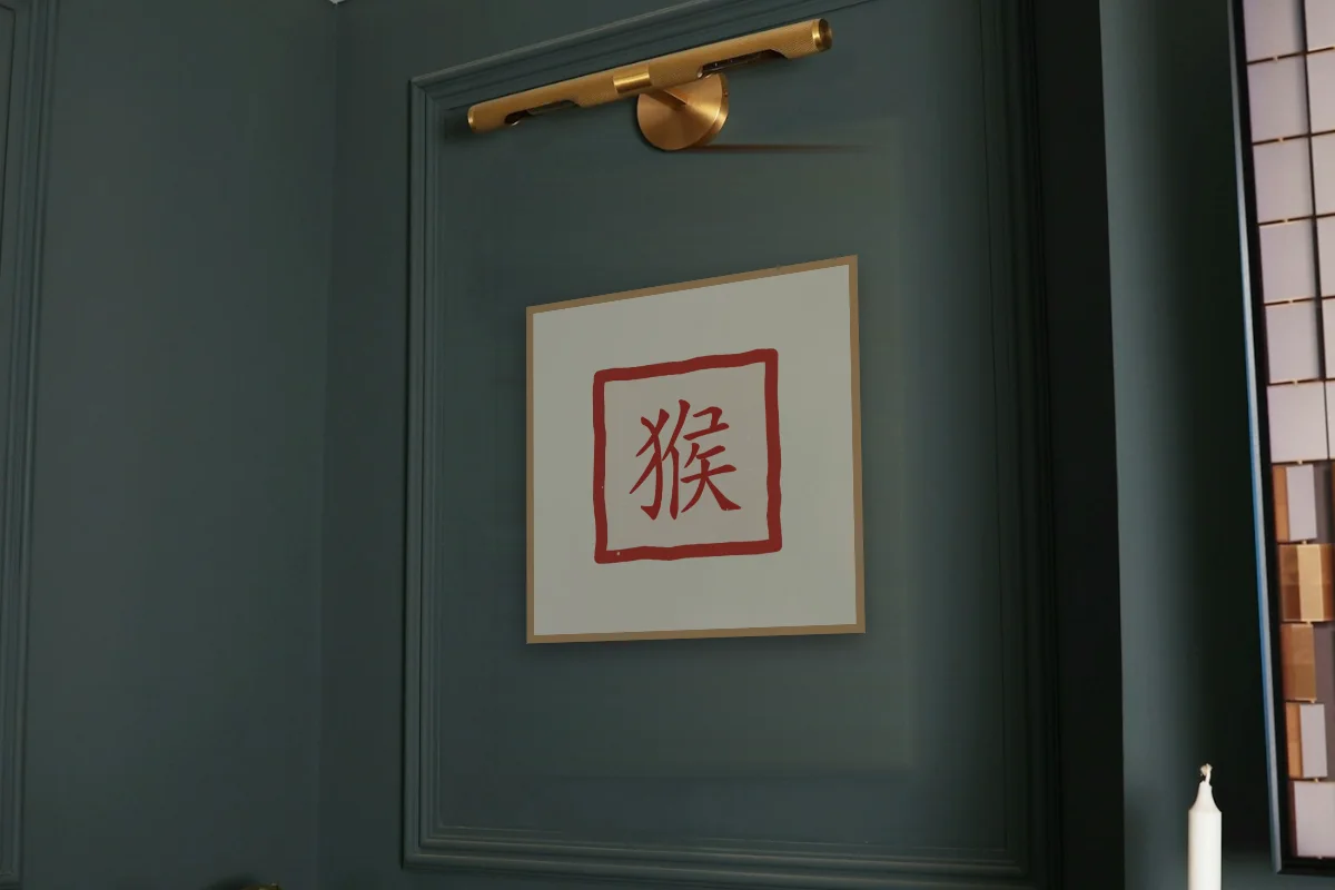 Signe du Singe en sceau, papier xuan. Photo d'illustration : Affiche encadrée chêne sous une lampe de tableau, mur vert profond, œuvre en 50 × 50 cm, à l'échelle. Photo de la pièce : Paul Yarnell (Unsplash).